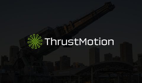 Thrustmotion logo over darkened image of a public railgun transport network.